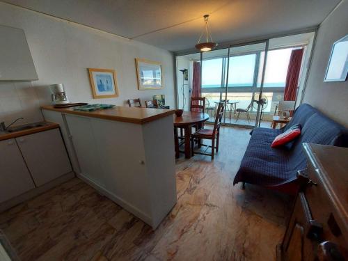 une cuisine et un salon avec une table et des chaises dans l'établissement Appartement 2 pièces avec terrasse en front de mer à louer - FR-1-423-181, au Grau-dʼAgde