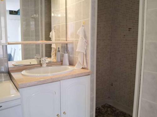une salle de bain avec un lavabo et une douche dans l'établissement Maison 3 pièces, 5 couchages avec terrasse et piscine, parking privé, à Marseillan - FR-1-326-705, à Marseillan