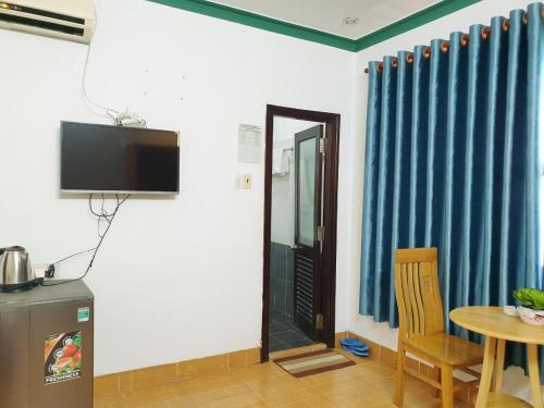 a room with a table and a television and a table and a chair at Mũi Dinh Hotel in Phan Rang
