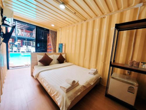 a bedroom with a bed with two towels on it at Retro Box Hotel Chumphon in Chumphon