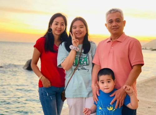 a family posing for a picture on the beach at Mũi Dinh Hotel in Phan Rang