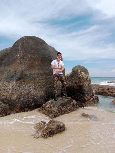 a man standing on a rock on the beach at Mũi Dinh Hotel in Phan Rang