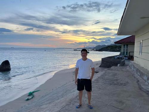 a man standing on the beach near the water at Mũi Dinh Hotel in Phan Rang
