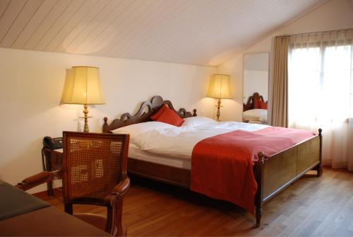 a bedroom with a large bed with a red blanket at Farbhaus by Kreuz Sachseln in Sachseln