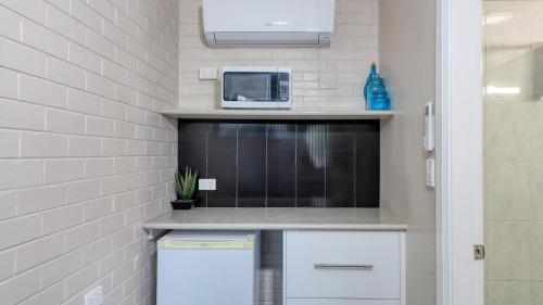 a kitchen with a microwave and a counter top at Country Leisure Motor Inn in Dubbo