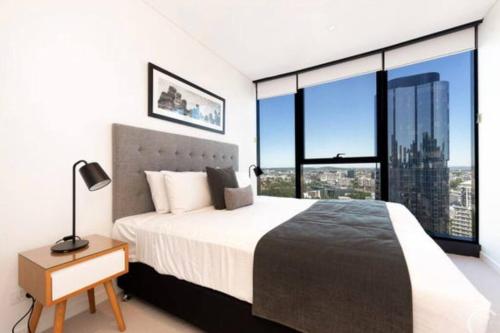 Un dormitorio con una cama grande y grandes ventanales. en L19 Spacious Apt, Wi-Fi, Parking by Stylish Stays, en Brisbane