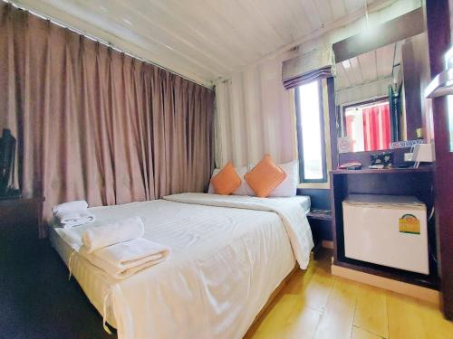 a hotel room with a bed with towels on it at Retro Box Hotel Chumphon in Chumphon