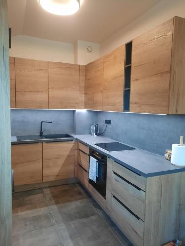 a kitchen with wooden cabinets and a sink at Apartment - Golden Fox 18 - Pohorske terase in Pohorje