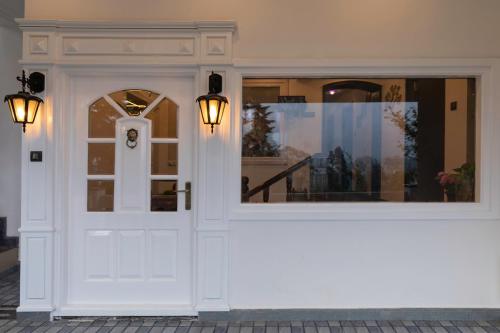 una porta bianca di un edificio con luci di Heritage View a Ooty
