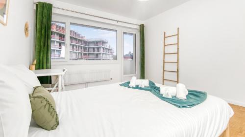 Un dormitorio blanco con una cama blanca y una ventana en HOMEY LA COLOC BRILLANT - Colocation haut de gamme de 3 chambres uniques et privées / Proche centre-ville et transports en commun / Balcons / Wifi gratuit, en Annemasse
