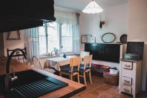 a kitchen with a table and a dining room at Chaloupka pod skalou in Libošovice
