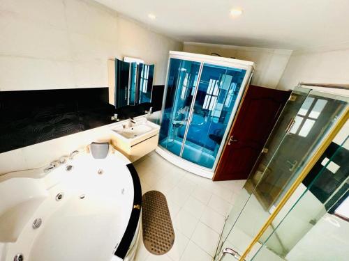 een badkamer met een bad, een wastafel en een douche bij Hostmandu B&B in Pātan
