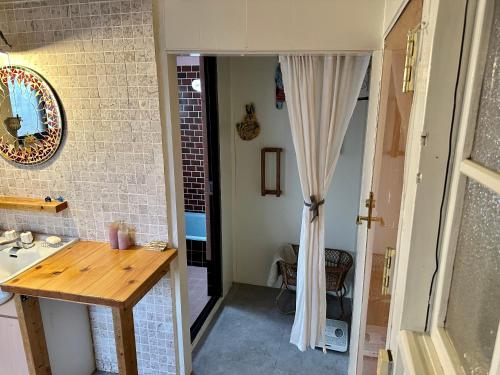 - une cuisine avec un évier et une table dans une chambre dans l'établissement 犬と泊まれる平屋Dog friendly house 黄昏, à Misaki