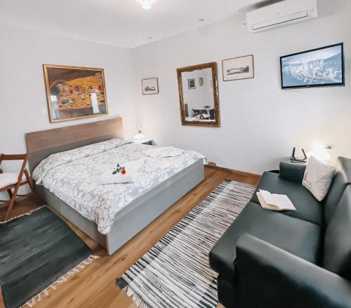 ein Schlafzimmer mit einem Bett und einem Sofa in der Unterkunft Galini Studios Paralia Platanou in Akráta