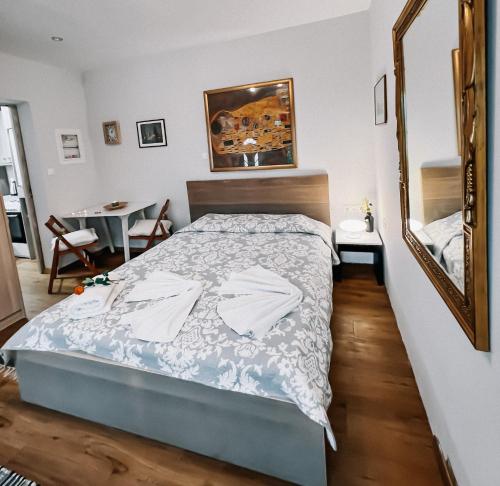 a bedroom with a bed and a mirror and a table at Galini Studios Paralia Platanou in Akrata