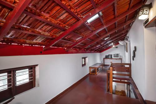 Cette chambre est dotée de plafonds rouges et de poutres apparentes. dans l'établissement Anamala Serenity Homestay Kerala, à Lakkidi