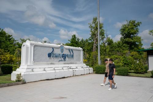 two people walking in front of a large monument at Maitria Mode Sukhumvit 15 Bangkok - A Chatrium Collection in Bangkok