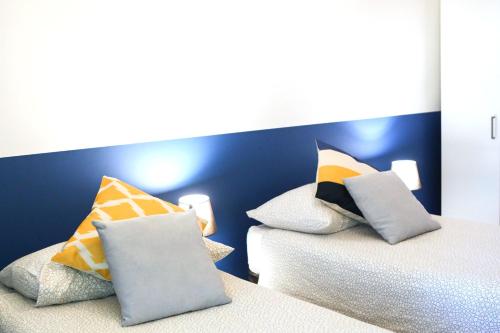 a bedroom with two beds with colorful pillows at Materdays 24 in Naples