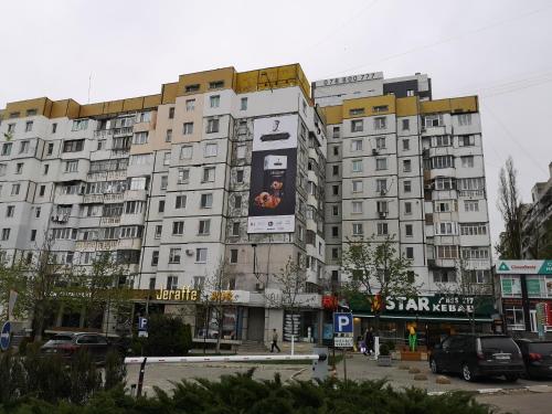 un gran edificio blanco con un gran cartel en Stylish apartment on street Ismail 84, en Chişinău