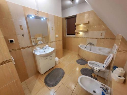 a bathroom with a sink and a toilet and a tub at Apartament w górach, obok centrum Mszana Dolna in Mszana Dolna