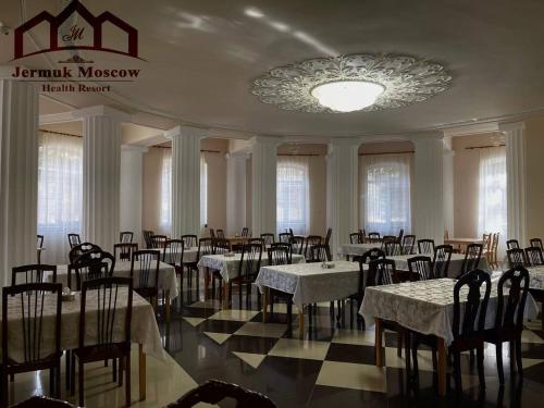 a dining room with tables and chairs and a chandelier at Jermuk Moscow Health Resort in Jermuk