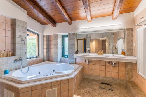 y baño grande con 2 lavabos y bañera. en Villa Evakri en Palaiokastro