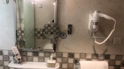 La salle de bains est pourvue d'une douche et d'un téléphone mural. dans l'établissement فيولا للشقق المخدومة, à Riyad