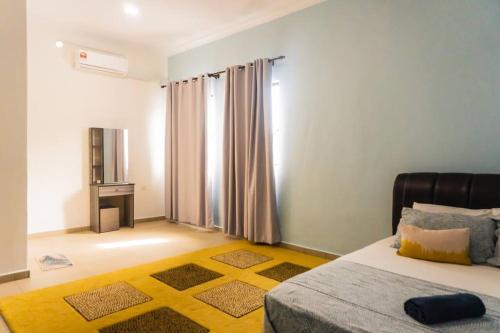 a bedroom with a bed with a yellow rug and a window at 2 Storey Semi-D Homestay Nilai and KLIA, F1 Sepang with Pool in Nilai