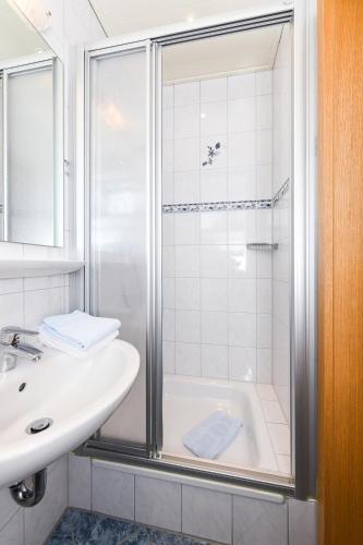 a bathroom with a shower and a sink at Hotel-Pension Marlies in Neuharlingersiel