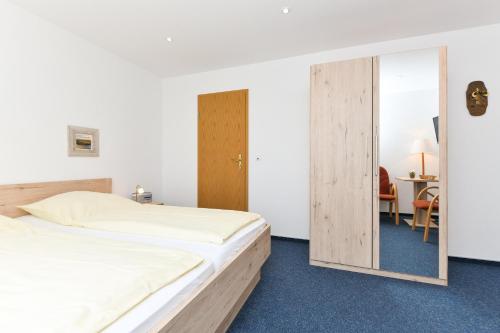 um quarto com 2 camas e um espelho em Hotel-Pension Marlies em Neuharlingersiel