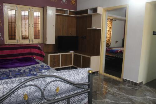 a bedroom with a bed and a tv and a mirror at pavan's villa in Hampi
