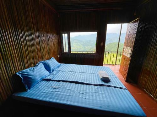 een groot bed in een houten kamer met een raam bij Mâm Xôi Homestay 