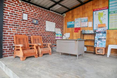 a brick wall with two chairs and a desk at Chom Dao Resort in Ko Lanta