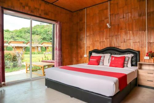 a bedroom with a large bed and a sliding glass door at Chom Dao Resort in Ko Lanta