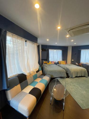 een woonkamer met 2 bedden en een bank bij spaceMU in Osaka