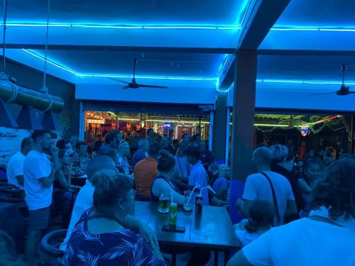 a crowd of people sitting at tables in a bar at Holiday Phangan - Hostel & Bar in Thongsala