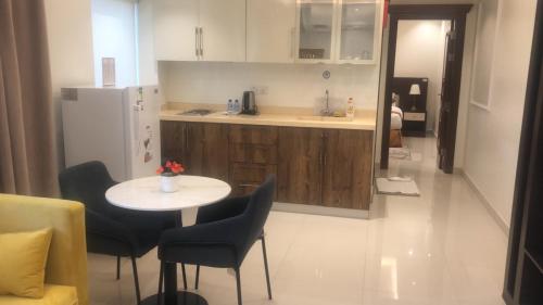 a kitchen with a table and chairs and a refrigerator at فيولا للشقق المخدومة in Riyadh