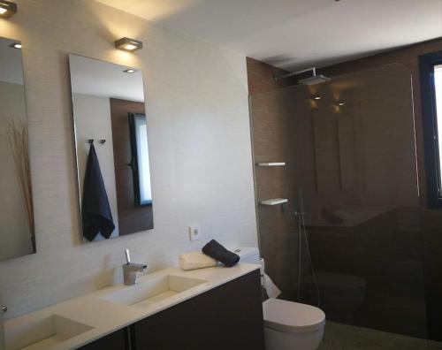 a bathroom with a sink and a toilet and a mirror at Precioso chalet vanguardista in Palma de Mallorca