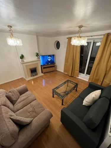 a living room with a couch and a tv at San Pedro- Anchorage in North Woolwich