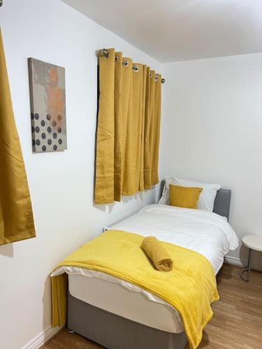 a bedroom with a bed with a yellow blanket on it at San Pedro- Anchorage in North Woolwich