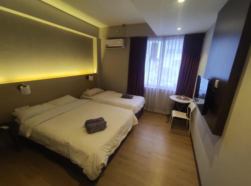 a hotel room with two beds and a television at EZ Suites in Bandar Seri Begawan