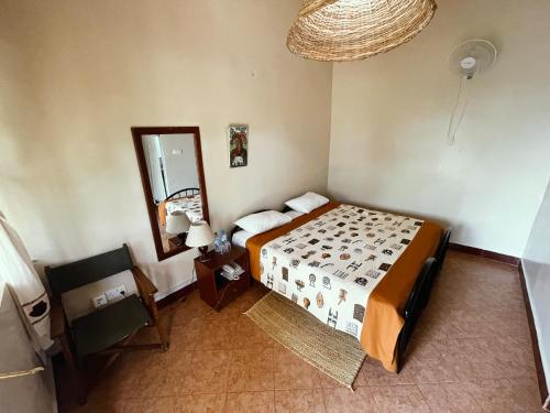 a bedroom with a bed and a mirror and a chair at Maktau Mountain Lodge in Kirongo