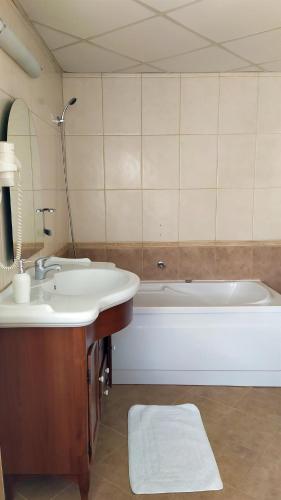 a bathroom with a sink and a bath tub at Hotel Mara in Baia Mare