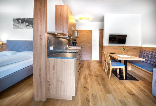 a kitchen and dining room with a bed and a table at Appartementhaus Madlen in Hinterstoder