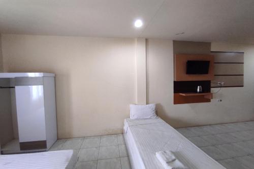 Habitación de hotel con cama y TV en OYO 92089 Hotel Subur, 