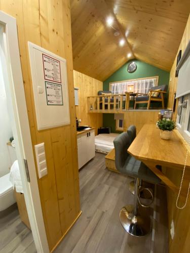een kleine kamer met een bureau en een kamer met een bed bij Tiny House Ahse im PIER9 Tiny House Hotel in Hamm