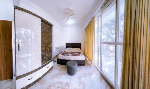 a bedroom with a bed and a large window at RVR Home - Beautiful Rooms in Bangalore