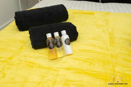 a group of three bottles on top of a bed at Hermes Apartment - The Messenger of Town in Southampton