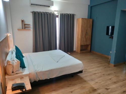 a bedroom with a bed in a room with blue walls at Divine Inn Couple Friendly Hotel near Sector 51 Metro Station in Noida