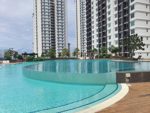 a large swimming pool with tall buildings in the background at Cozy Spacious Home 2 BR SKS Habitat Larkin JB in Johor Bahru